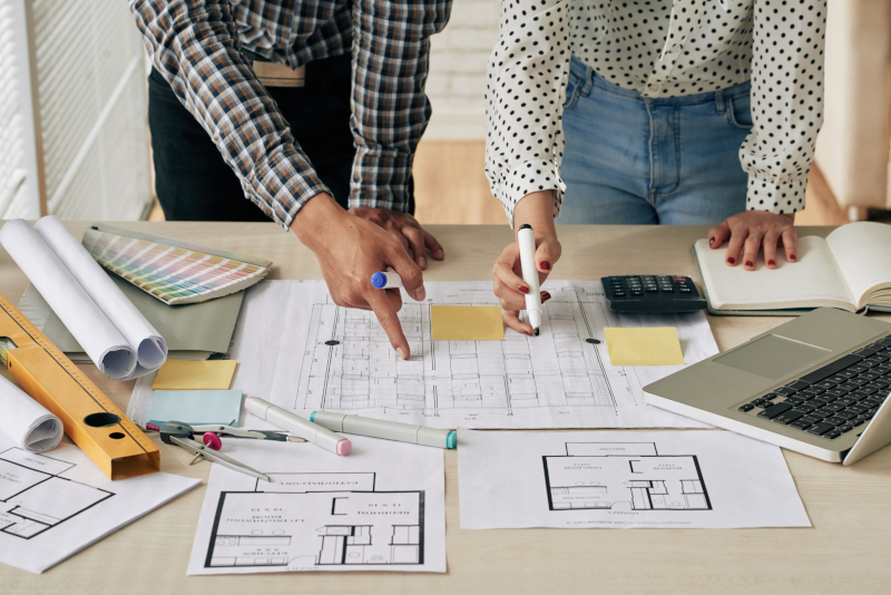 Young male architect at desk with schematics